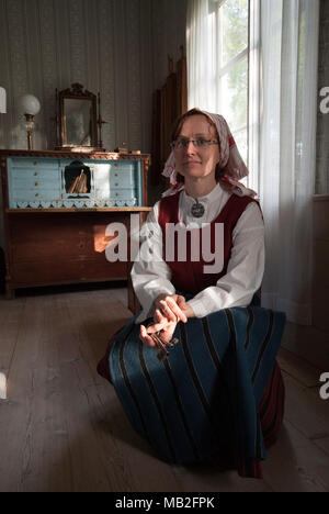 Jeune femme en costume traditionnel, maison ancienne en Martingarden, Musée Overkalix, comté de Norrbotten, en Suède Banque D'Images