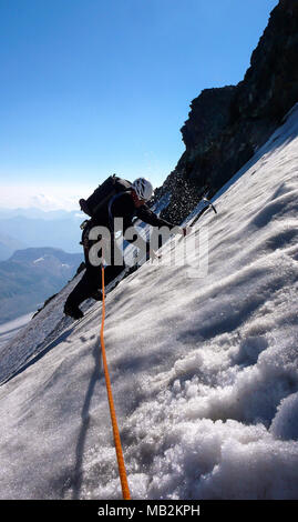 D'alpiniste traverse une pente raide et exposé glacier suspendu avec une très belle vue derrière Banque D'Images