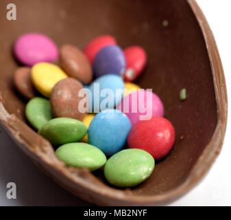 Smarties à l'intérieur d'un oeuf de pâques en chocolat Banque D'Images