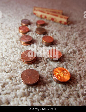 Des piles de pièces d'un Américain en cuivre sont alignés sur un tapis en préparation pour le mettre dans des rouleaux de papier 50. Banque D'Images