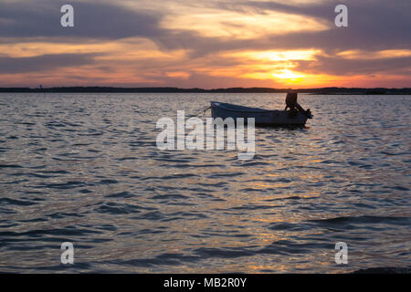 Seul bateau au coucher du soleil, inclinant doucement dans les eaux du son. Juste à l'extérieur de Harkers Island, Caroline du Nord. Le bateau attend le pêcheur Banque D'Images