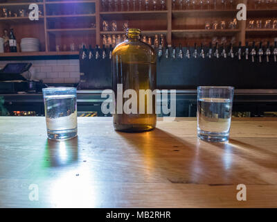 Cruche d'eau et tasses sur le dessus de bar brasserie Banque D'Images