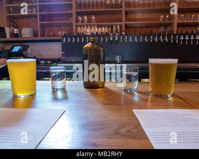 Pot à eau, tasses, bière, brunch spéciaux sur comptoir bar brasserie dans Banque D'Images