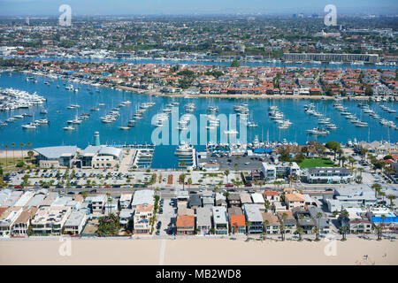 VUE AÉRIENNE. Péninsule de Balboa au premier plan avec l'île du Lido entre les deux cours d'eau. Newport Beach, Orange County, Californie, États-Unis. Banque D'Images