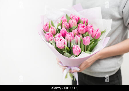 Tulipes de couleur rose femme dans la main. Gros bourgeons. Décor naturel floral. Fleurs insolites, contrairement aux autres. L'accent peu profondes. Fond d'écran, photo horizontale Banque D'Images