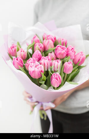 Tulipes de couleur rose femme dans la main. Gros bourgeons. Décor naturel floral. Fleurs insolites, contrairement aux autres. L'accent peu profondes. Fond d'écran, photo verticale Banque D'Images