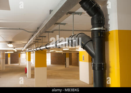 Système de tuyaux d'eaux usées voie émerger dans un parking souterrain du complexe d'appartements au-dessus. Banque D'Images