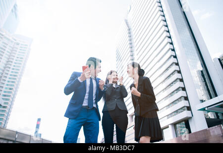 Célébrer la réussite. Low angle view of young businessman excité et femme d'affaires positif exprimant tout en se tenant à l'extérieur, je Banque D'Images