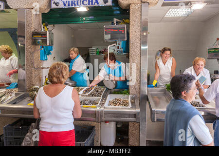 Poissonnier dans le traditionnel marché intérieur/extérieur avec calage du vendeur du Mercado de Abastos de Santiago, Santiago de Compostelle, Galice, Espagne Banque D'Images