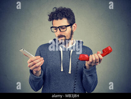 Jeune homme hipster à nous interroger au sujet des gadgets à l'ancienne et contemporaine. Banque D'Images