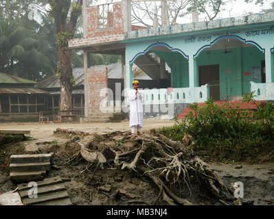 Boy vu debout devant le bâtiment de l'école. Dans le delta des rivières Ganga (Padma), du Brahmapoutre et de la Meghna personnes vivent sur l'eau. La zone autour de la ville Banaripara est inondé avec de l'eau. Les gens vivent dans des villages sur les rives de rivières. Le transport routier n'est possible. Juste de l'eau et les navires les connecter avec le reste du monde. Mais le quartier est très animé. Les agriculteurs cultivent des fruits, des légumes, du riz et des cultures sur 2 700 kilomètres carrés de terres entre les rivières. Visitez les fournisseurs leur client sur les bateaux. Marchés flottants avec des légumes, des fruits, du riz ou du bois sont communs dans ce domaine. Les gens Banque D'Images