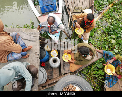 Fournisseurs prendre un petit déjeuner dans la bateau de "fast food" dans le marché flottant. Dans le delta des rivières Ganga (Padma), du Brahmapoutre et de la Meghna personnes vivent sur l'eau. La zone autour de la ville Banaripara est inondé avec de l'eau. Les gens vivent dans des villages sur les rives de rivières. Le transport routier n'est possible. Juste de l'eau et les navires les connecter avec le reste du monde. Mais le quartier est très animé. Les agriculteurs cultivent des fruits, des légumes, du riz et des cultures sur 2 700 kilomètres carrés de terres entre les rivières. Visitez les fournisseurs leur client sur les bateaux. Marchés flottants avec des légumes, des fruits, du riz ou du bois sont commo Banque D'Images