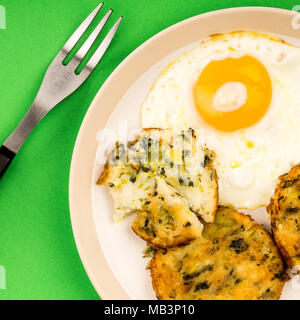 Végétarien cuisiné et Squeak Bulle les gâteaux avec un Œuf frit sur fond vert Banque D'Images