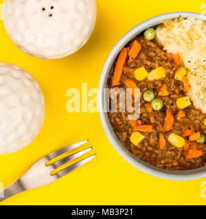 Cottage Pie nourrissant repas dans un bol sur fond jaune Banque D'Images