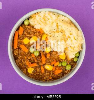 Cottage Pie nourrissant repas dans un bol contre fond violet Banque D'Images