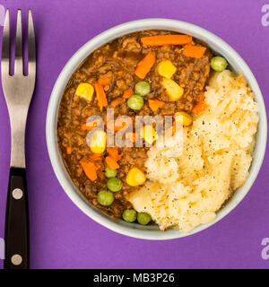 Cottage Pie nourrissant repas dans un bol contre fond violet Banque D'Images