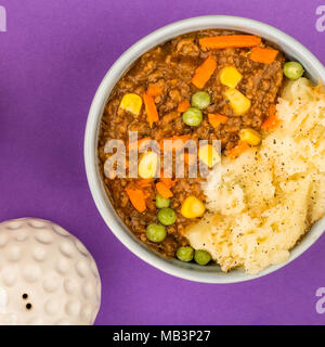 Cottage Pie nourrissant repas dans un bol contre fond violet Banque D'Images