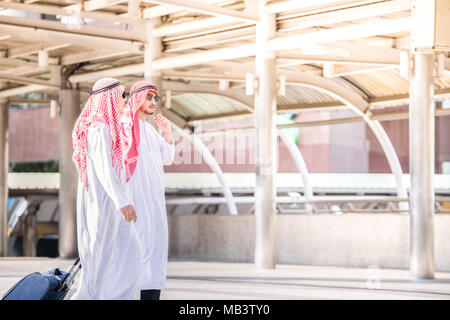 Du Moyen-Orient arabe businessman doing business trip et marcher à l'aéroport tout en portant une assurance Banque D'Images