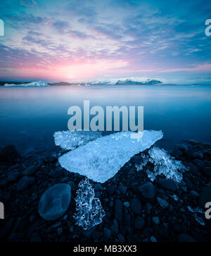 Glacier jökulsárlón lagoon avec blocs de glace et de montagnes à beau coucher du soleil en Islande Banque D'Images