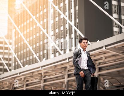 Happy Asian businessman walking le long de la rue Banque D'Images