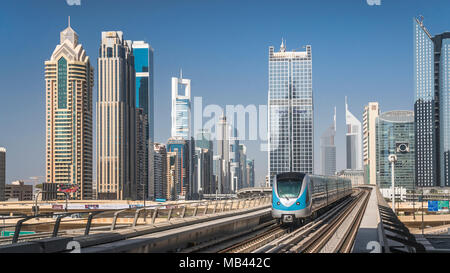 Un train de métro de Dubaï et du centre-ville de tours de bureaux en Dujbai, ÉMIRATS ARABES UNIS, au Moyen-Orient. Banque D'Images