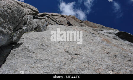 Male rock climber sur une pente raide route de granit dans les montagnes près de Chamonix dans les Alpes Françaises Banque D'Images