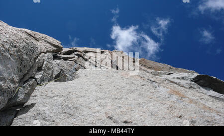 Male rock climber sur une pente raide route de granit dans les montagnes près de Chamonix dans les Alpes Françaises Banque D'Images