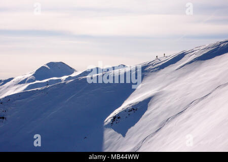 Deux randonneurs randonnée sur une longue crête de montagne vers le sommet près de Klosters dans les Alpes Suisses en hiver profonde Banque D'Images