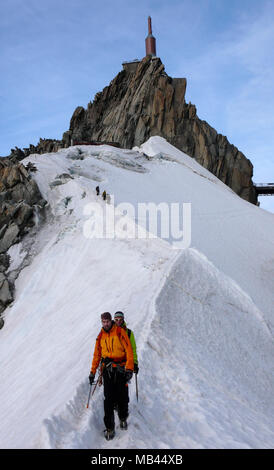 Guide de montagne et d'un patient sur une crête rocheuse en direction d'un haut sommet dans les Alpes françaises près de Chamonix Banque D'Images