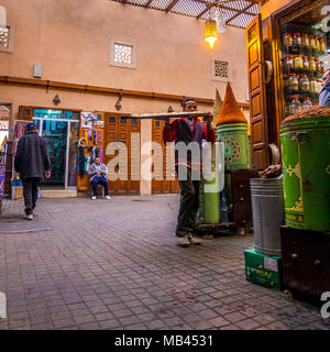 L'homme avec le bac de marchandises dans des souks de Marrakech, Maroc Banque D'Images