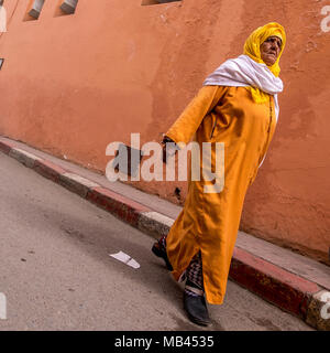 Vieille Femme marche dans les rues de souks de Marrakech, Maroc Banque D'Images