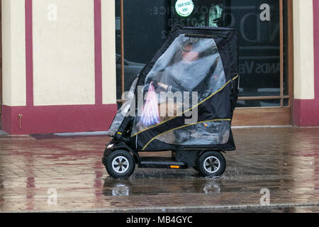 Utilisateur de fauteuil roulant à Blackpool Lancashire. Météo britannique. 07/04/2018. Humide, détrempé, jour de pluie à Blackpool avec pluie devenir persistantes et de fortes averses parfois grâce à l'après-midi. /AlamyLiveNews MediaWorldImages Crédit : Banque D'Images