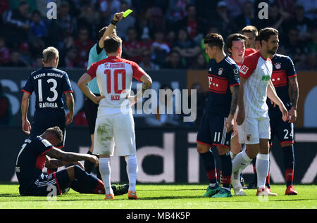 Augsbourg, la Russie. 7 avril 2018. Soccer : Bundesliga, FC Augsburg vs FC Bayern Munich, dans l'Arène WWK. Arbitre Markus Schmidt (C, caché) montrant le Michael Gregoritsch Augsbourg (2R) un carton jaune alors que Munich's Jerome Boateng se trouve sur le terrain. Photo : Sven Hoppe/DPA - AVIS IMPORTANT : En raison de la Ligue allemande de football (DFL)·s règlement d'accréditation, la publication et la redistribution en ligne et dans les médias en ligne est limité pendant le match à 15 images par match : dpa Crédit photo alliance/Alamy Live News Crédit : afp photo alliance/Alamy Live News Crédit : afp photo/Alamy L alliance Banque D'Images