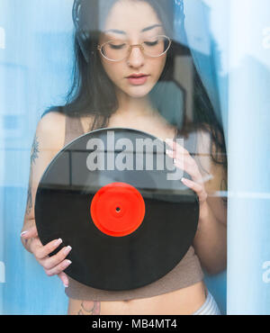 Jolie fille une adolescente derrière l'écoute de la musique avec des écouteurs et vinyles à out Banque D'Images