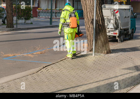 Paysagiste nettoyage travailleur pied façon park à partir de feuilles mortes. À l'aide de ventilateur de feuille électrique Banque D'Images