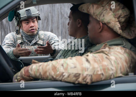 Airman First Class Marvin Bumanglag et Bronson Lee, fireteam membres du 154e Escadron des Forces de sécurité, de coordonner les plans de sécurité avec Garciea Vaughn, Mississippi Department of Wildlife, Pêches et des Parcs, l'équipe d'intervention spéciale, au cours de l'effort privé Sud Patriot, le 13 février 2018, au camp Shelby, Mississippi Les aviateurs ont été "temporairement" eputized par la police locale afin de servir comme d'un service d'appui à travers les événements d'une simulation de tremblement de terre. Banque D'Images