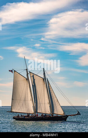 Voilier de croisière voiles entièrement gréé sur un océan calme sous un ciel bleu nuageux dans la vue latérale de l'été vacances conceptuel Banque D'Images