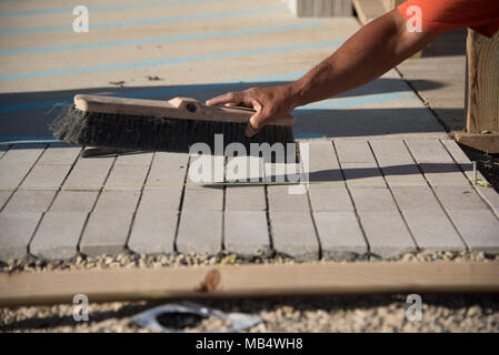 Vue de près des travailleurs après la pose de briques de béton sur couche de sable Banque D'Images