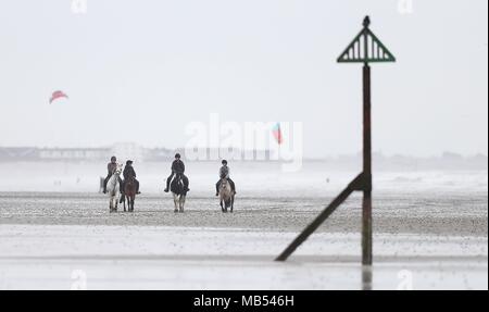Les cavaliers font leur chemin le long de West Wittering beach dans le West Sussex. Banque D'Images