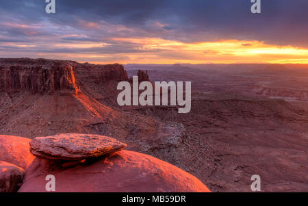 Le soleil qui s'allume et la Butte de jonction dans le ciel de l'île de Canyonlands National Park, en Utah. Banque D'Images