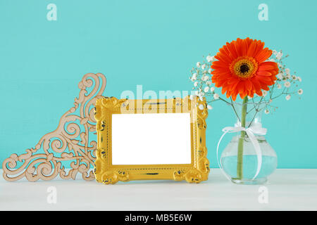 Image de beau bouquet de fleurs au printemps suivant pour blank vintage photo frame sur table en bois. Pour la photographie montage maquette Banque D'Images