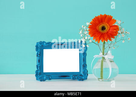 Image de beau bouquet de fleurs au printemps suivant pour blank vintage photo frame sur table en bois. Pour la photographie montage maquette Banque D'Images