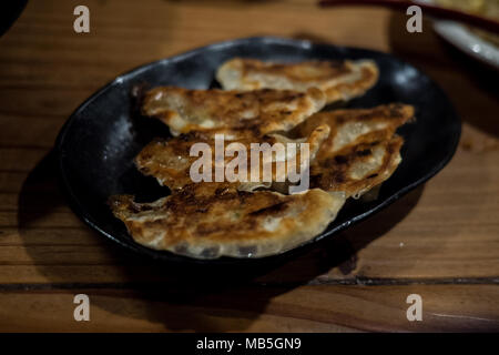 Gyoza frits parfaitement servi sur une plaque noire, également connu sous le nom de beignets japonais Banque D'Images