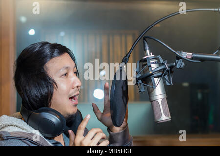 Jeune chanteuse asiatique l'enregistrement d'une chanson avec micro de studio de musique Banque D'Images
