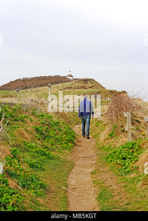 Un marcheur sur le chemin de la côte de Norfolk approchant Skelding Hill à Sheringham, Norfolk, Angleterre, Royaume-Uni, Europe. Banque D'Images