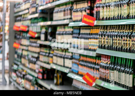 Différents types de bière sur les tablettes dans le supermarché. floue. Banque D'Images