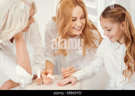 Granny tendre maman et enfant enseignement sex pour peindre les ongles Banque D'Images