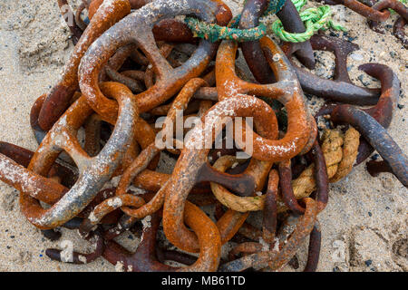 Un vieux rusty corrodés chaîne d'ancre avec une anse de rejoindre sans poumons rejeté et portant sur une plage de sable. Câble d'ancrage situé sur la rive de la rouille Banque D'Images