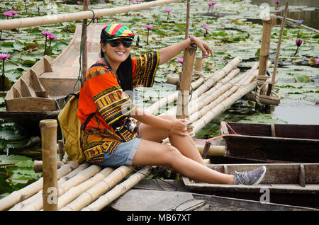 Les voyageurs asiatiques femme thaïlandaise travel visiter et pour prendre le pont de bambou de séance photo avec bateau flottant en bois avec de l'eau lily dans l étang à jardin de la Lo Banque D'Images