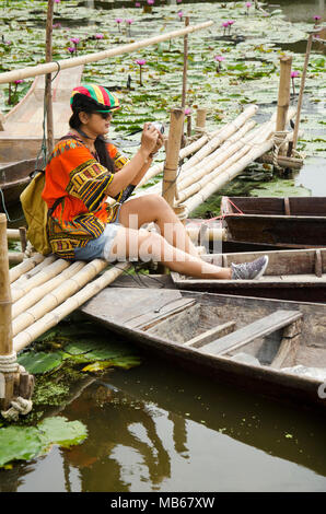 Les voyageurs asiatiques femme thaïlandaise travel visiter et pour prendre le pont de bambou de séance photo avec bateau flottant en bois avec de l'eau lily dans l étang à jardin de la Lo Banque D'Images